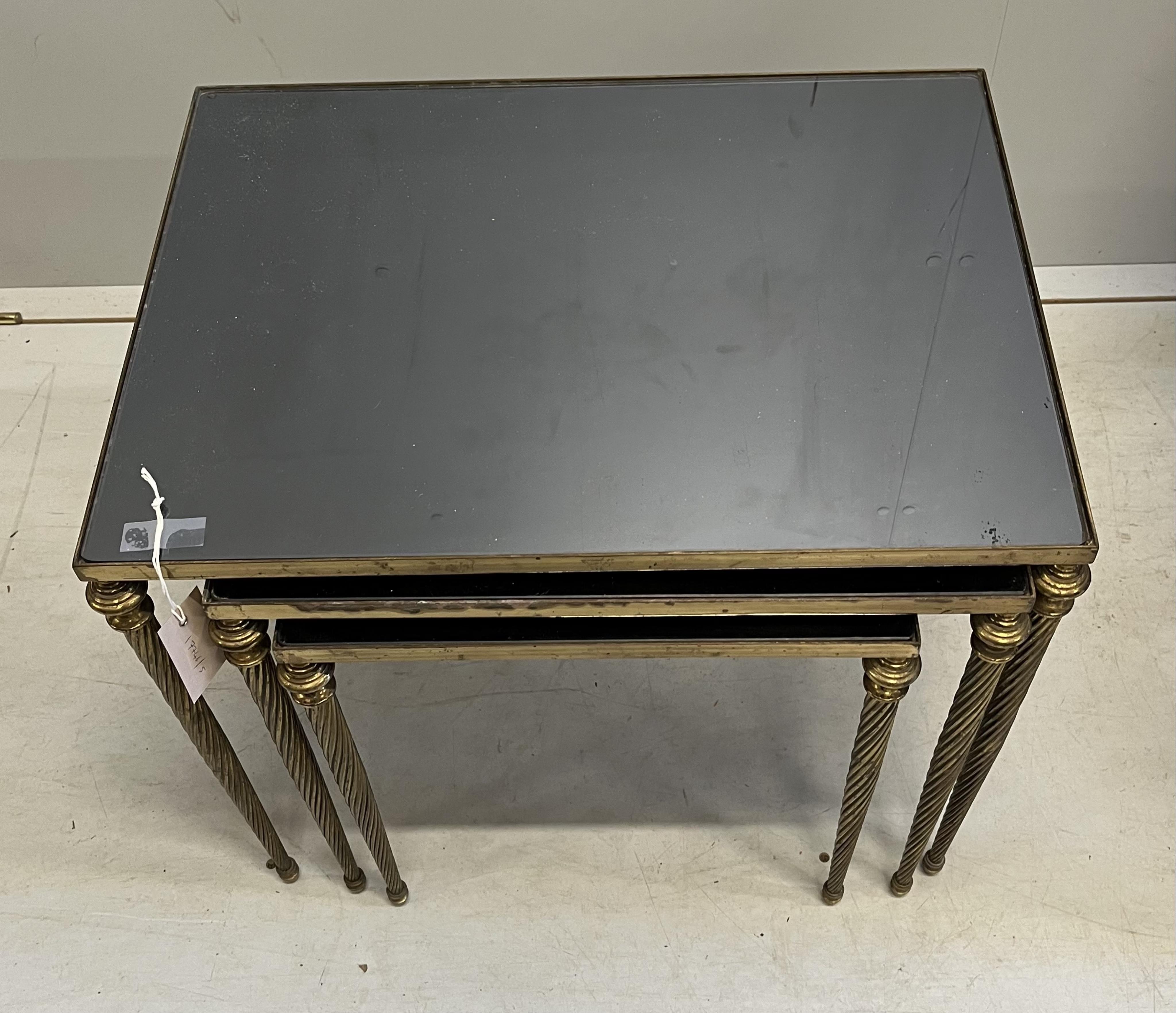 A nest of three brass and smoked glass tables, width 54cm, depth 40cm, height 45cm